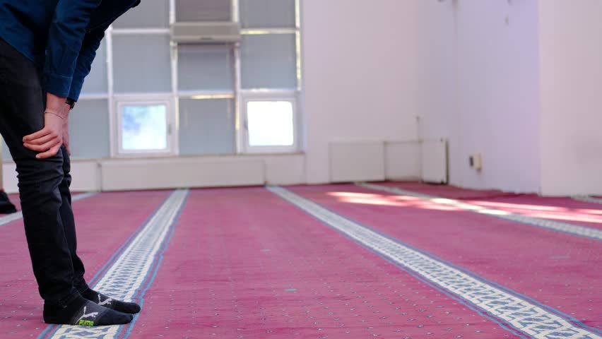 Muslim man masked praying with his forehead ground, man who believes in islam prays in mosque, islam is a holy religion