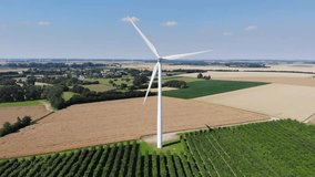 Aerial drone view of wind trubines and green and yellow fields in Normandy, France
