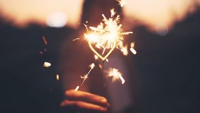 Hand of woman hold glow burn fireworks heart shape sparkler at sunset, love, valentine's day. - Powered by Shutterstock - Get 15% off with code: PIKWIZARD15