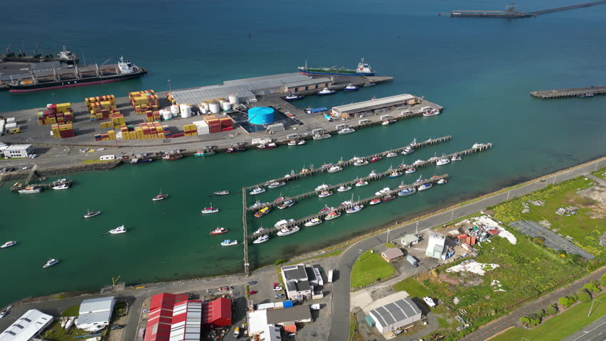 Industrial harbor in Bluff region, New Zealand, aerial drone orbit view