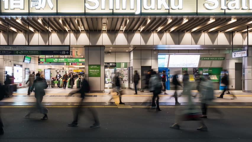 Tokyo, Japan - Dec 2, 2022: Time lapse of Japanese people, crowd Asian commuter walking at JR Shinjuku subway station entrance at night. Asia transport, urban city life, train transportation concept