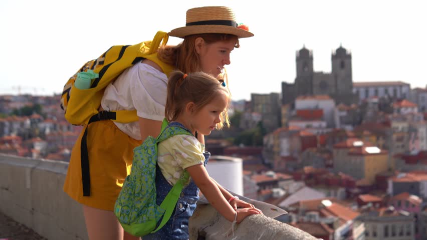 Happy family traveling. Young red-haired mother and little daughter looking on the Porto city, Portugal Royalty-Free Stock Footage #1099849629