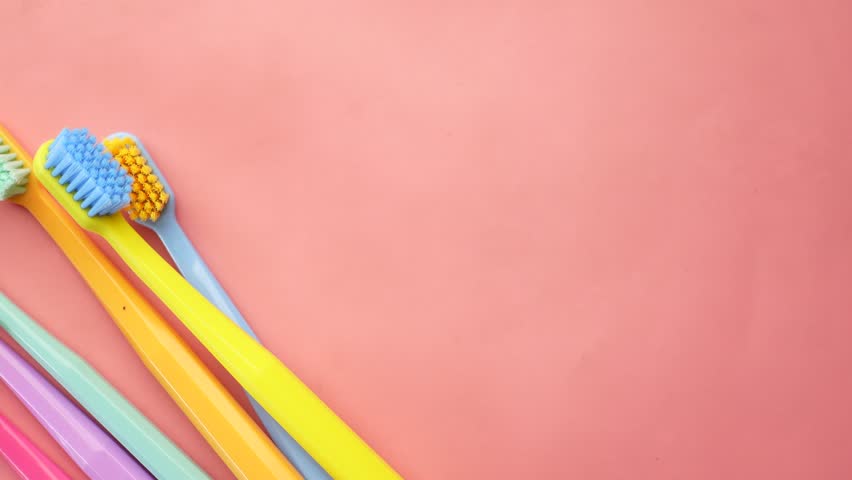  colorful toothbrushes on a pick background  | Shutterstock HD Video #1099853195