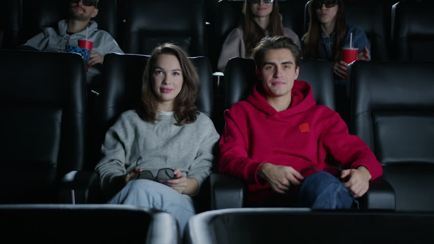For the first time in a 3D cinema. A woman and a man put on glasses to watch a movie. Surprised people, emotions | Shutterstock HD Video #1099853667