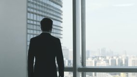 asian business man walking up to the window looking at the city in office - Powered by Shutterstock - Get 15% off with code: PIKWIZARD15
