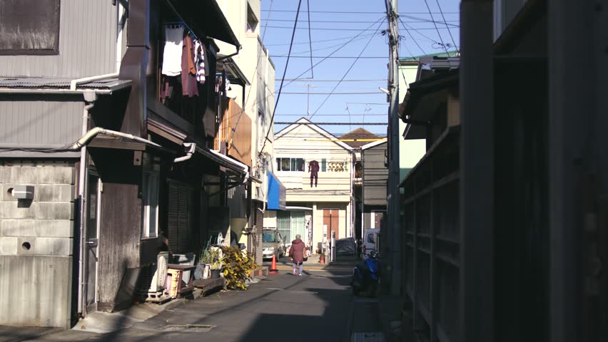 An old Japanese alley, with an old man going into the corner