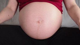 Close-up of unrecognizable pregnant woman caressing her tummy
