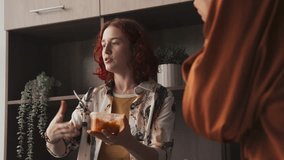 Young woman wearing casual clothes holding container with her meal talking to her co-workers during lunch break in modern office - Powered by Shutterstock - Get 15% off with code: PIKWIZARD15