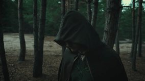 Portrait fantasy male elf prince takes off hood from head. Dark gothic dense forest. Mystical evil face fairy guy. Wizard man. Creative medieval clothes cloak cape green costume. Fashion model posing - Powered by Shutterstock - Get 15% off with code: PIKWIZARD15