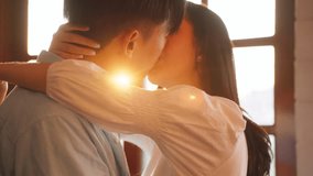 Asian young man and woman kissing each other in living room at home. Attractive romantic new marriage couple male and female spend time celebrate anniversary and valentine's day together in house. - Powered by Shutterstock - Get 15% off with code: PIKWIZARD15
