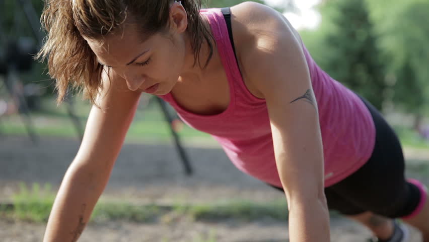 Athletic and Beautiful Woman doing Push-Ups in Central Park in NYC