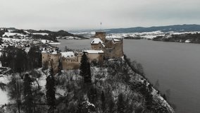 Old castle in the winter on the top of the hill next to a lake - Drone Video - D-Cinelike
