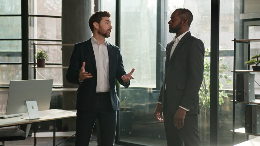 Two diverse men multiracial businessmen talking in office shake hands after successful negotiations. Caucasian man seller handshake African American business partner client partnership deal agreement Royalty-Free Stock Footage #1099872263