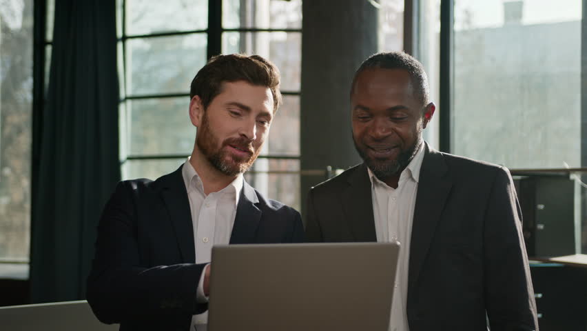Caucasian professional male business expert man advice software pointing on laptop consulting African American client customer investor about online trading digital investment explain data at office | Shutterstock HD Video #1099872271