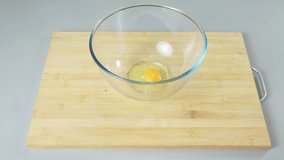Adding a tablespoon of salt to raw eggs in a bowl before beating them. Making dessert or scrambled eggs. High quality 4k footage