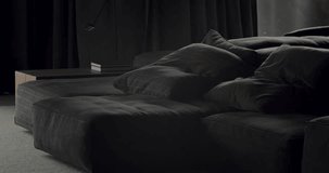 Modern contemporary Minimalist living room with black furniture and big black drapes. Luxury Modern House Interior With Corner Sofa and Bookshelf. Fashionable furniture. Luxury Elegant Room