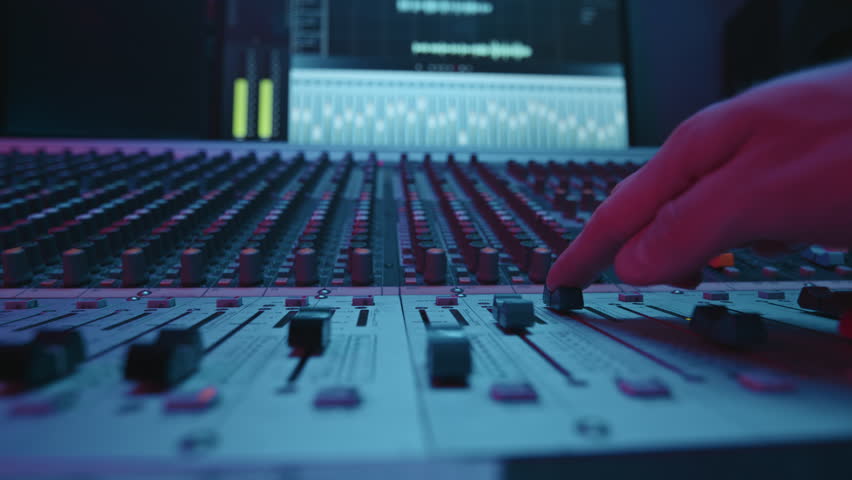 Hand of operator or musician moving console forwards while leveling noise and adjusting sounds in process of creating new music and recording it in studio | Shutterstock HD Video #1099876017
