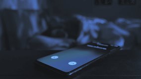 infidelity love affair,close up on mobile phone receiving incoming call while a married couple sleep on bed in the background,betrays cheating concept - Powered by Shutterstock - Get 15% off with code: PIKWIZARD15