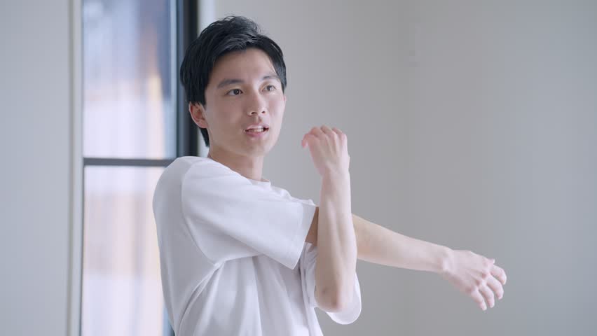 Young Asian man stretching in his room