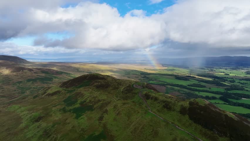 Drone Approach of Conic Hill in Scotland with Rainbow Behind