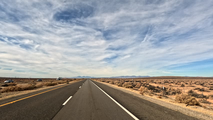 Driving through the Mojave Desert with wispy clouds in the sky