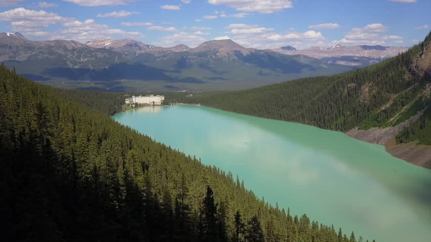 Aerial flyover: Glacial green Lake Louise with luxury chateau hotel