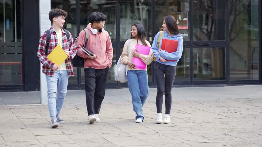 Group of international exchange university students going for lecture. Smiling girls and boys with books talking and walking around College campus Royalty-Free Stock Footage #1099895235