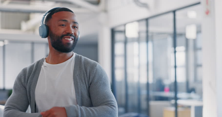Music, walking or happy black man greeting his team with a smile in headphones for radio audio in office. Creative, dance or excited funny person dancing with freedom, positive energy or motivation