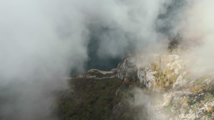 Aerial view clouds over Lake in canyon, Piva lake in Montenegro. fly through clouds