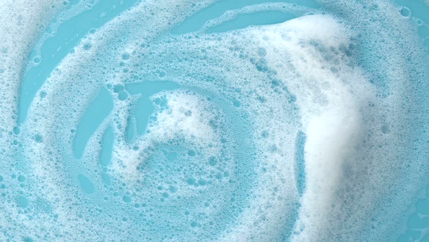 Rotating surface with white soap foam on blue background, texture of foam with bubbles, video 4k resolution | Shutterstock HD Video #1099905781