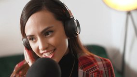 Woman wearing headphones recording a podcast for internet audience using a mic. High-quality 4k footage