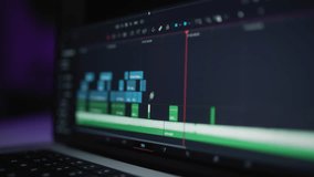 A human editor uses a laptop to creatively create a video clip. Makes color correction of video content. A freelance colorist works at home in the studio. The cinematographer is editing the film