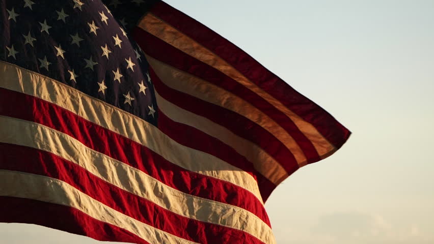 Memorial Day, American USA flag waving in the wind against sunset nature outdoor background, Slow Motion. Concept of American, 4th of July, Memorial Day, Independence Day, Veterans Day