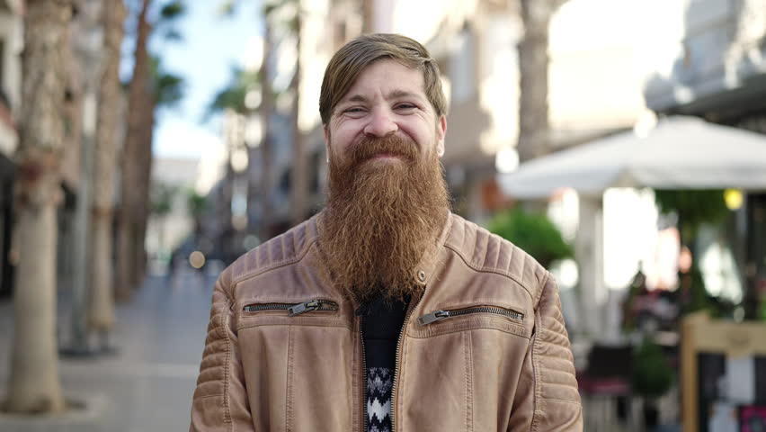 Young redhead man smiling confident pointing with finger at coffee shop terrace