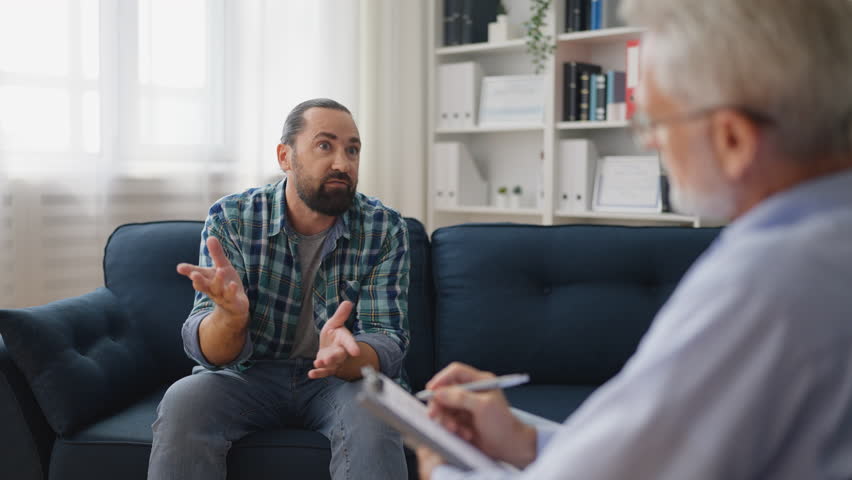 Man with traumatic experience talking with professional psychologist, therapy | Shutterstock HD Video #1099915747
