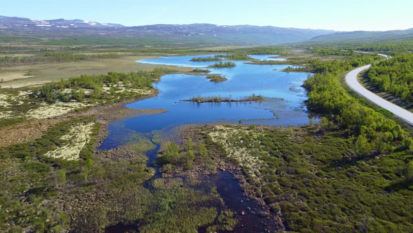 Flight over a landscape with lakes and lagoons in the Dovrefjell national park in Norway