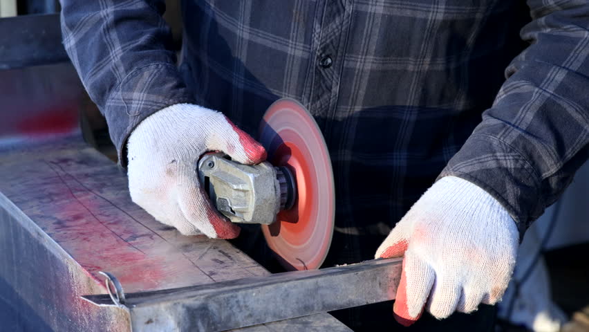 Worker using grinder, for cuts metal with grinder