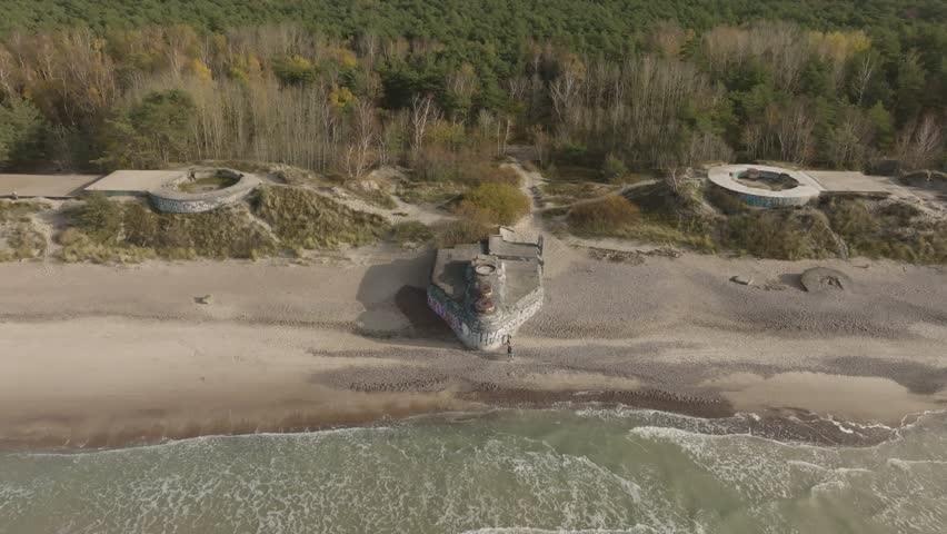 An aerial view of an abandoned WW2 defense bunker with cannon emplacements on the Baltic Seashore.