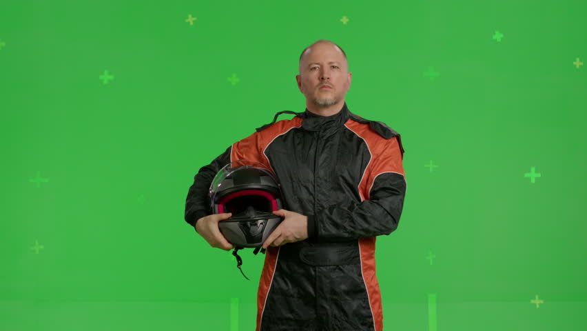 close-up racing driver standing in front of a green screen background, portrait of sports car racer wearing helmet , chroma key