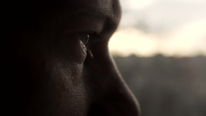 Dramatic isolated portrait of a man who opens his eyes and looks out the window with sad pensive look. Closeup of male eye. Slow motion. A man is worried and thinking while looking into the distance. | Shutterstock HD Video #1099919531