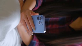 Vertical video of young girl browsing modern smart phone. Close up footage of female person using blue mobile phone - Powered by Shutterstock - Get 15% off with code: PIKWIZARD15