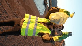 Young adult making video call showing a bag full of plastics collected from the beach. Social media influencer promoting recycling. Concept of environmental care. Vertical video - Powered by Shutterstock - Get 15% off with code: PIKWIZARD15