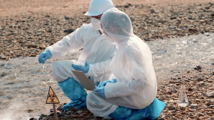 Biologist wear protective suit and mask collects sample of waste water from industry, problem environment, Ecologist sample taken dead fish to inspection and save data to laptop computer, Toxic water | Shutterstock HD Video #1099921859