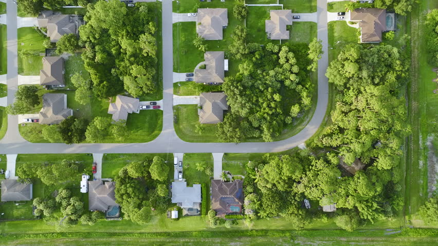 Aerial view of small town America suburban landscape with private homes between green palm trees in Florida quiet residential area Royalty-Free Stock Footage #1099922901