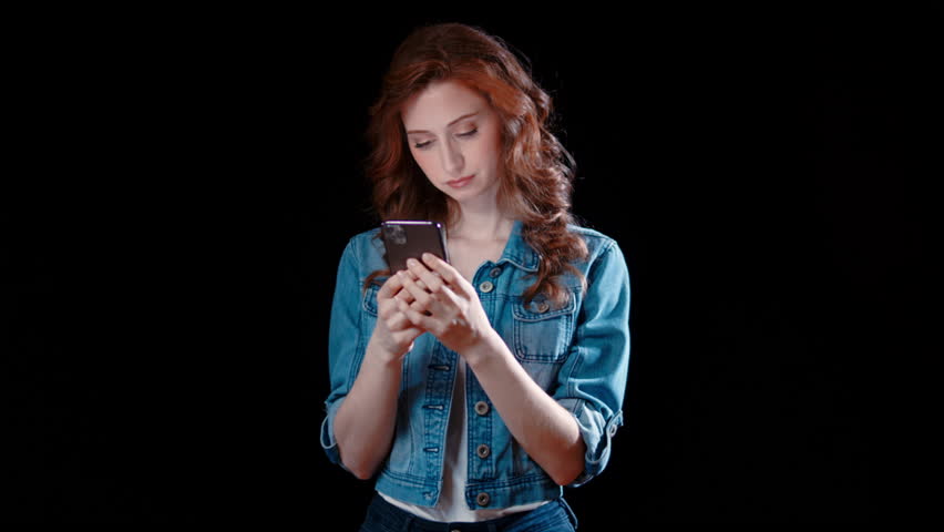 (Camera: ARRI ALEXA, 35mm lens, real time) A young caucasian woman texting, disappointed. For more variations of this clip, check out this seller's other videos. | Shutterstock HD Video #1099927353