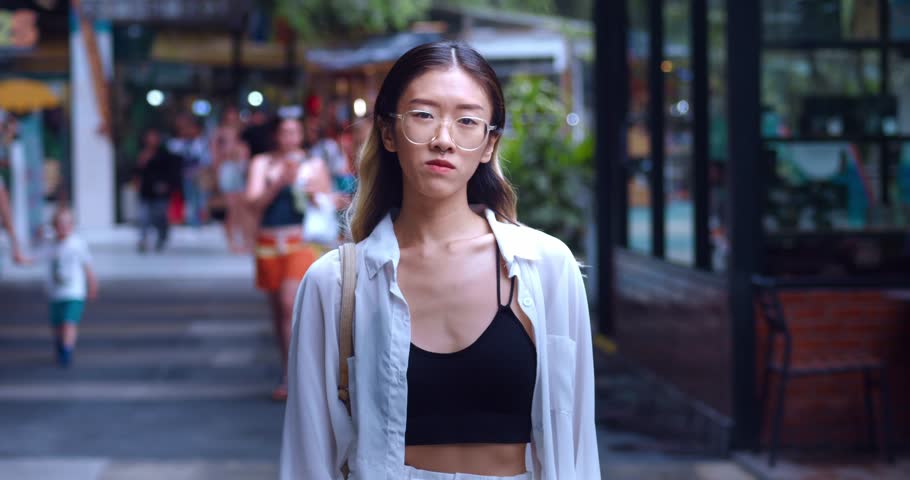 Portrait young asian female 20 student in glasses thumb down while shopping at mall. Asian woman gives a bad rating with thumb down. Concept of disapproval, bad recommendation, say no. | Shutterstock HD Video #1099932311