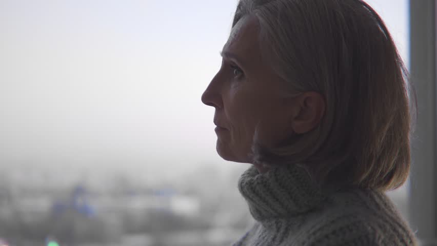 Mature gray-haired woman standing alone in unknown country, escaping from war | Shutterstock HD Video #1099935229