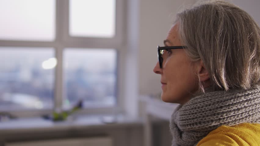 Mature woman looking at window sitting in doctor's office, scheduled examination | Shutterstock HD Video #1099935357