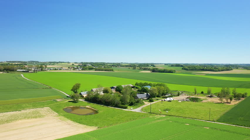A traditional Norman farmhouse in the middle of libn and barley fields in Europe, France, Normandy, towards Deauville, in summer, on a sunny day.