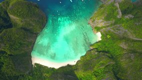 Tropical paradise islands, long white sandy beach and turquoise waters surrounded by limestone mountains. Maya Bay, Koh Phi Phi, Krabi, Thailand. One of the most beautiful beach in the world. 4K Drone